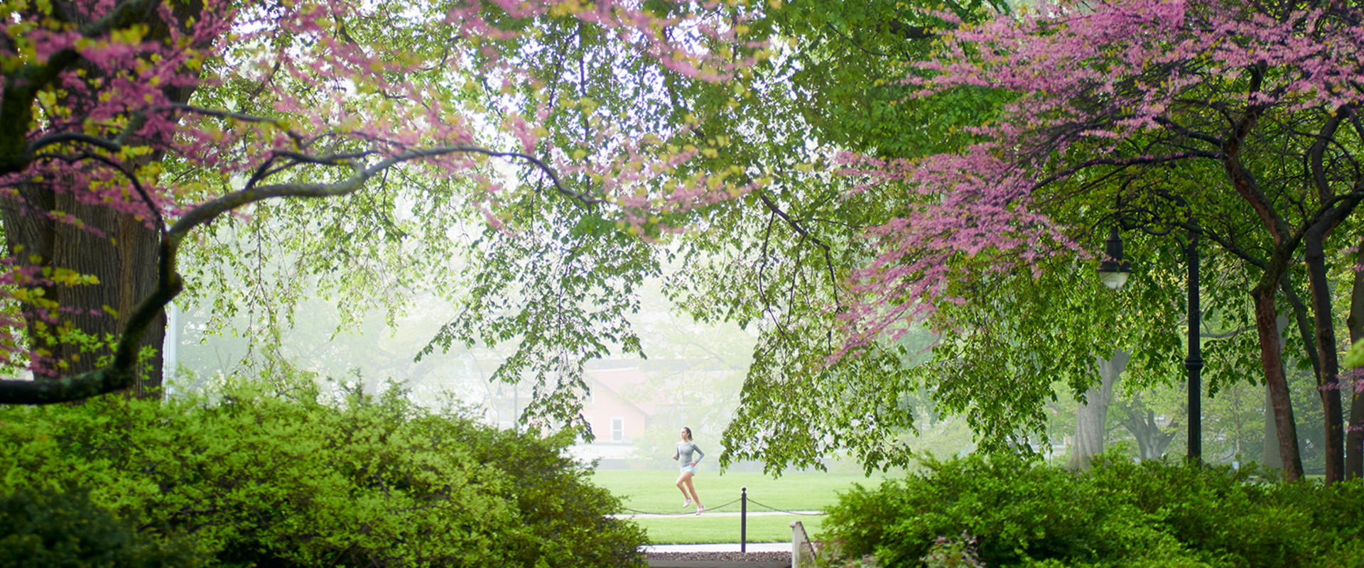 A jogger runs past Old Main during an early morning in spring